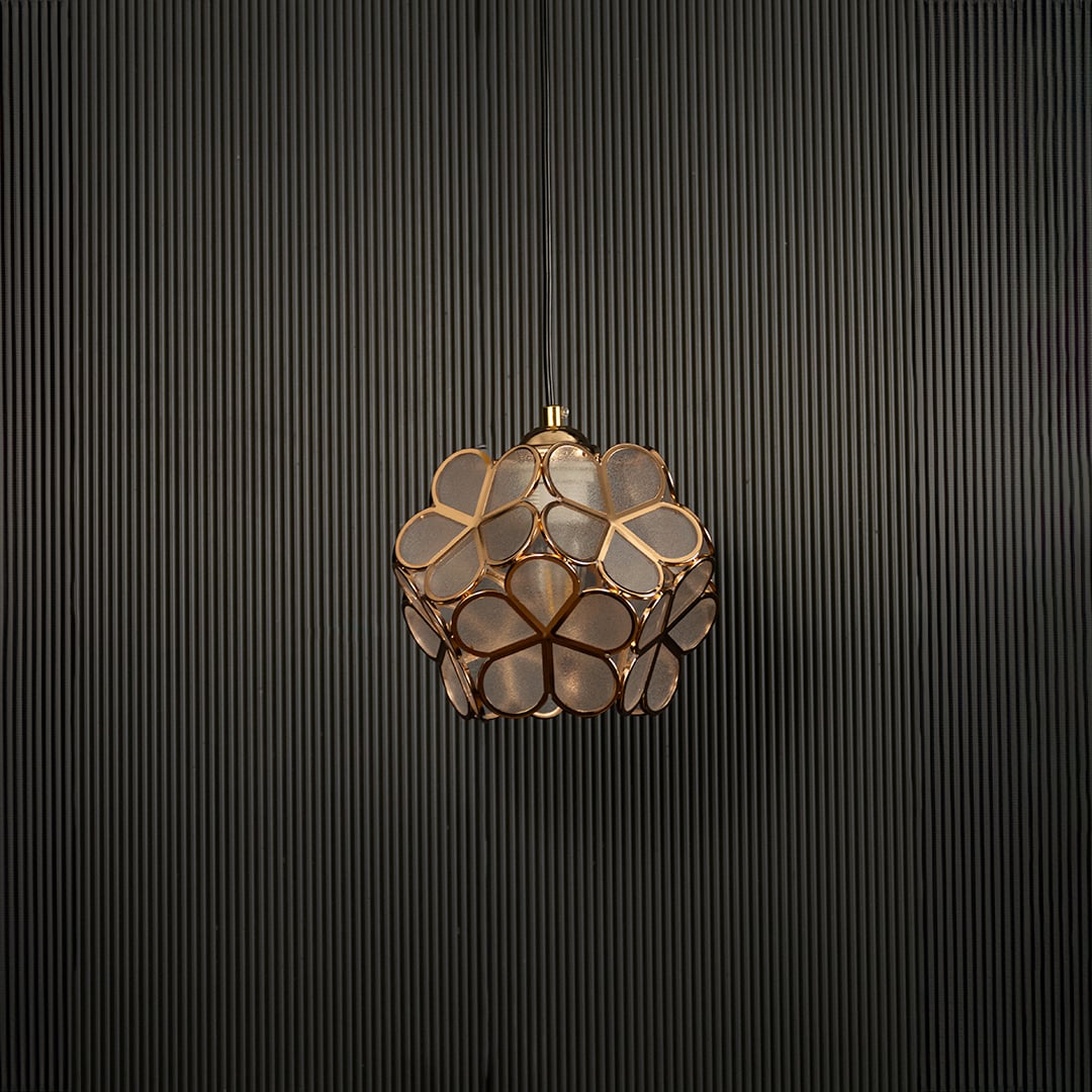 Modern gold flower pendant light displayed on dark background with light off highlighting elegant design details.