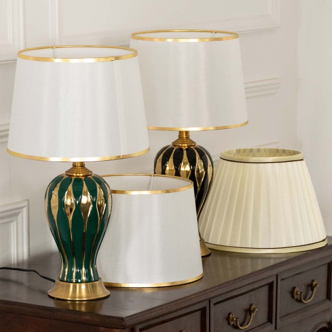 Table lamp with green and gold ceramic base and white shade shown in a curated decor setup for premium styling.