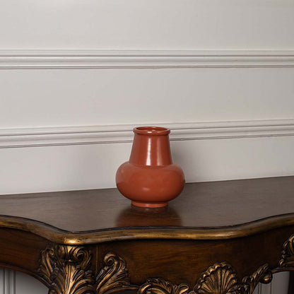 Minimal white background view of the orange ceramic vase showcasing its glossy surface and contemporary rounded design.