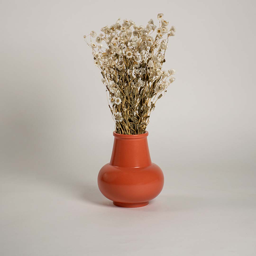 Orange ceramic vase displayed in a soft lifestyle setting creating a modern accent for shelf decor or living room styling.