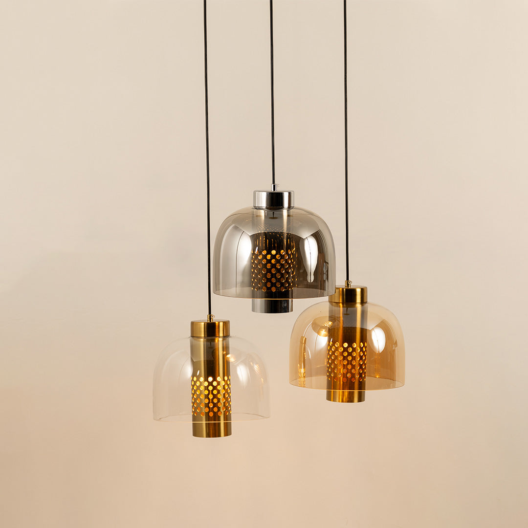 Modern amber glass pendant lights with metallic accents for luxury dining room and kitchen decor styling.