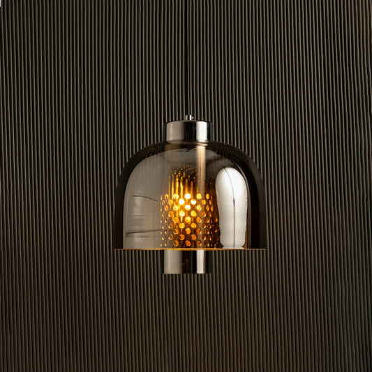 Smoke grey glass pendant light with dome shade casting warm ambient glow imagined against a dark background creating a dramatic modern interior decor atmosphere.