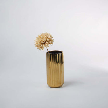 A reflective gold ribbed vase placed in a minimal scene offering a second lifestyle view that highlights its tall shape and modern metallic charm.