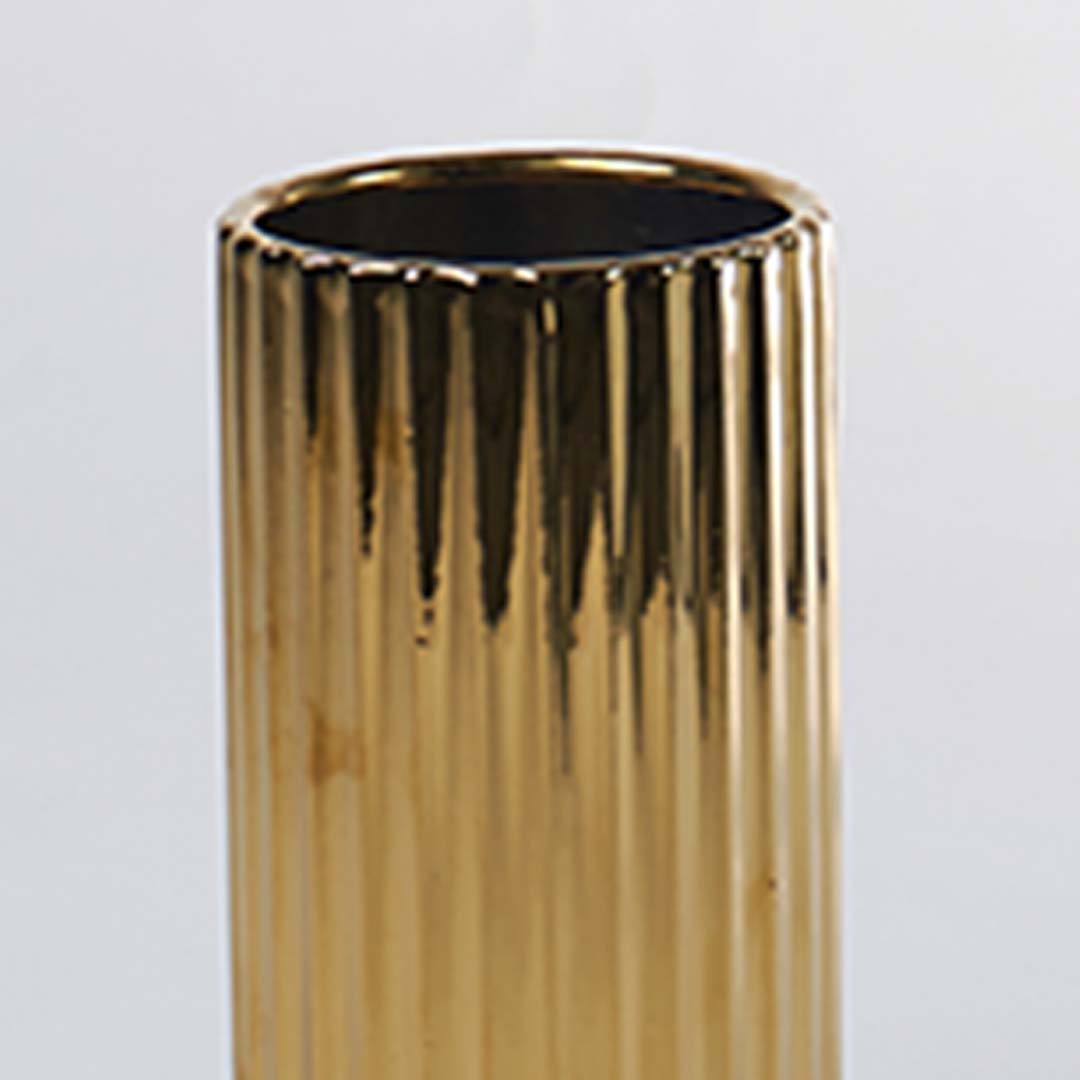 A detailed view of a gold ribbed vase capturing its glossy texture and refined finish creating a closeup look that enhances its elegant modern style.