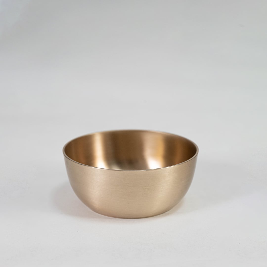 Plain brass tumbler with cylindrical shape and matte metallic finish displayed upright on clean white background.