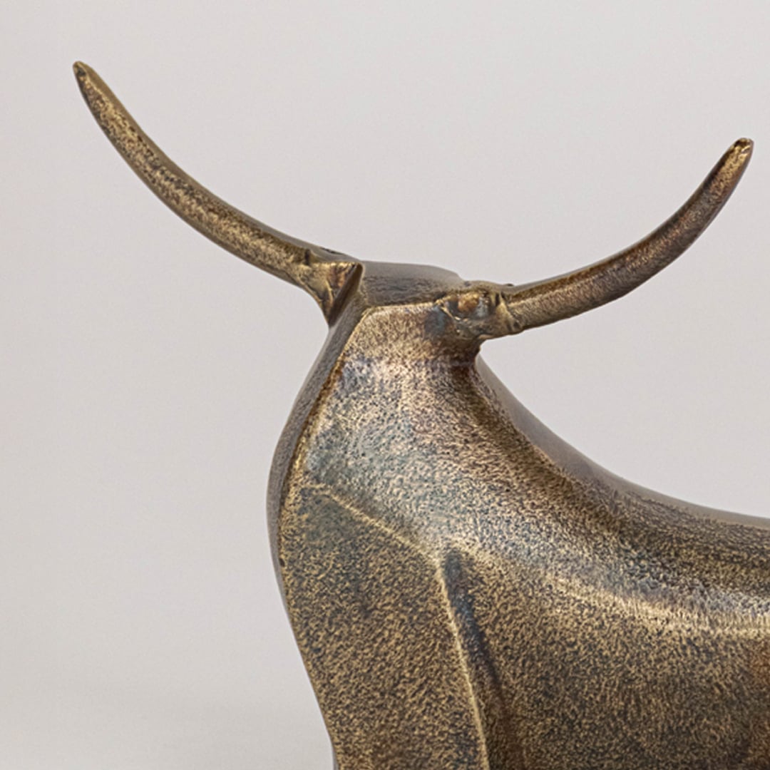 Stylized bronze bull decor shown in modern interior setting adding strength and charm to shelf or table displays