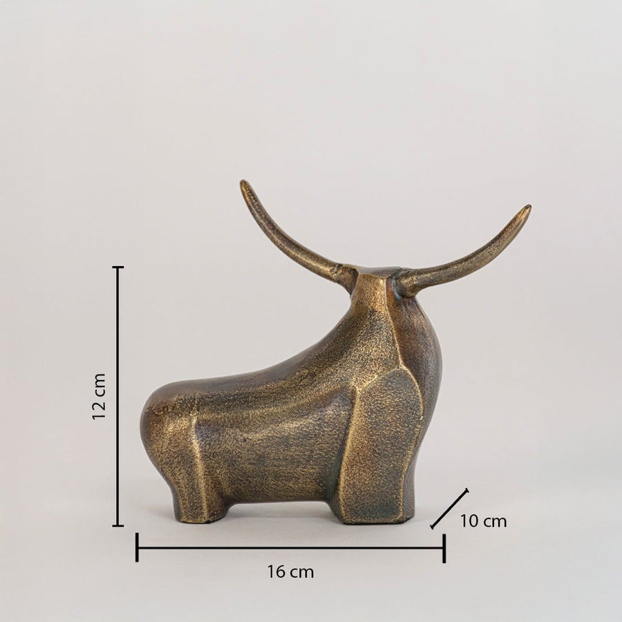 Decorative bronze bull statue measuring 12 cm high 16 cm wide and 10 cm deep with upward horns on white backdrop.