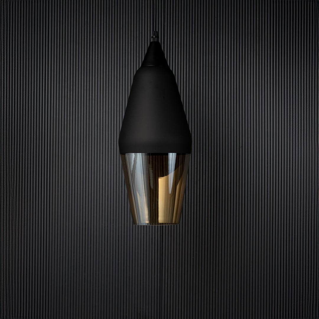 Pendant light turned off against a dark background showcasing the matte black top and translucent amber glass with a contemporary minimal look.