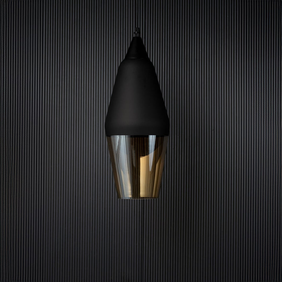 Pendant light turned off against a dark background showcasing the matte black top and translucent amber glass with a contemporary minimal look.