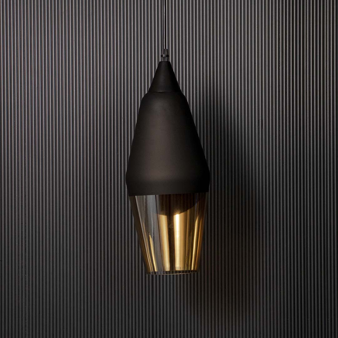 Modern pendant light with matte black cone shade and gold interior shown unlit on black background for contemporary ceiling decor.