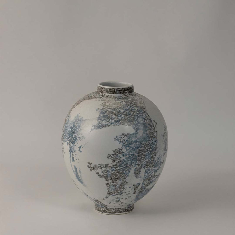 Side angle view of round ceramic vase with artistic grey and blue texture designed for elegant home interior decoration.