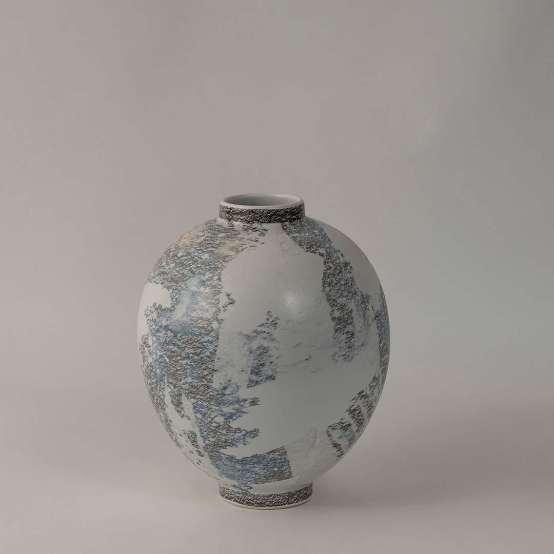 Elegant ceramic vase with grey and blue textured finish styled for modern living room and table decor on white background.
