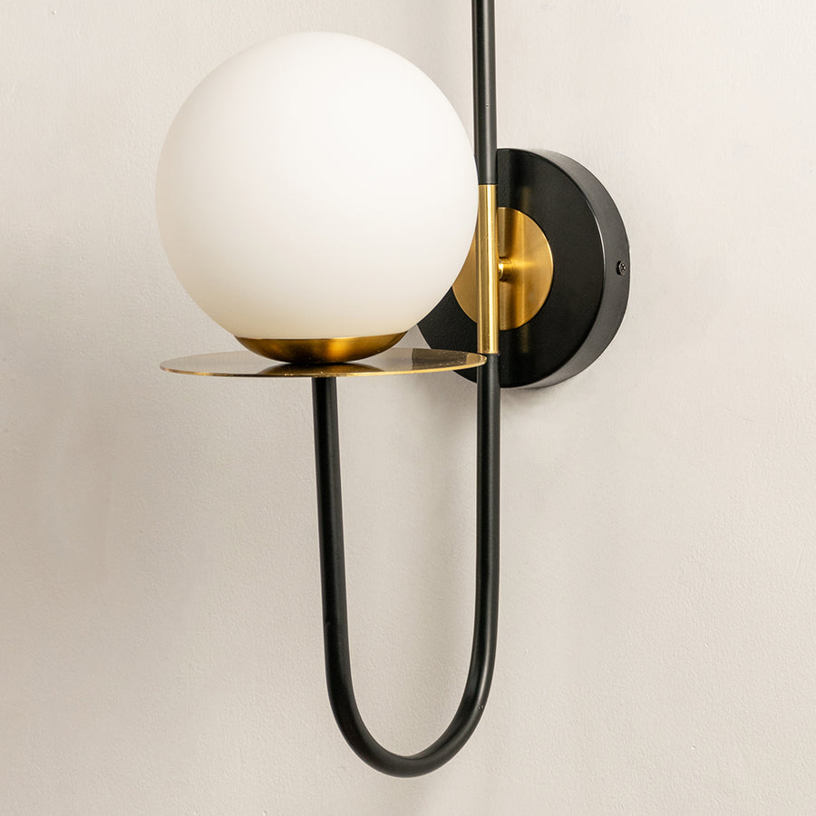Modern wall light with white glass globe and black metal frame perfect for contemporary interior wall decor on clean background.