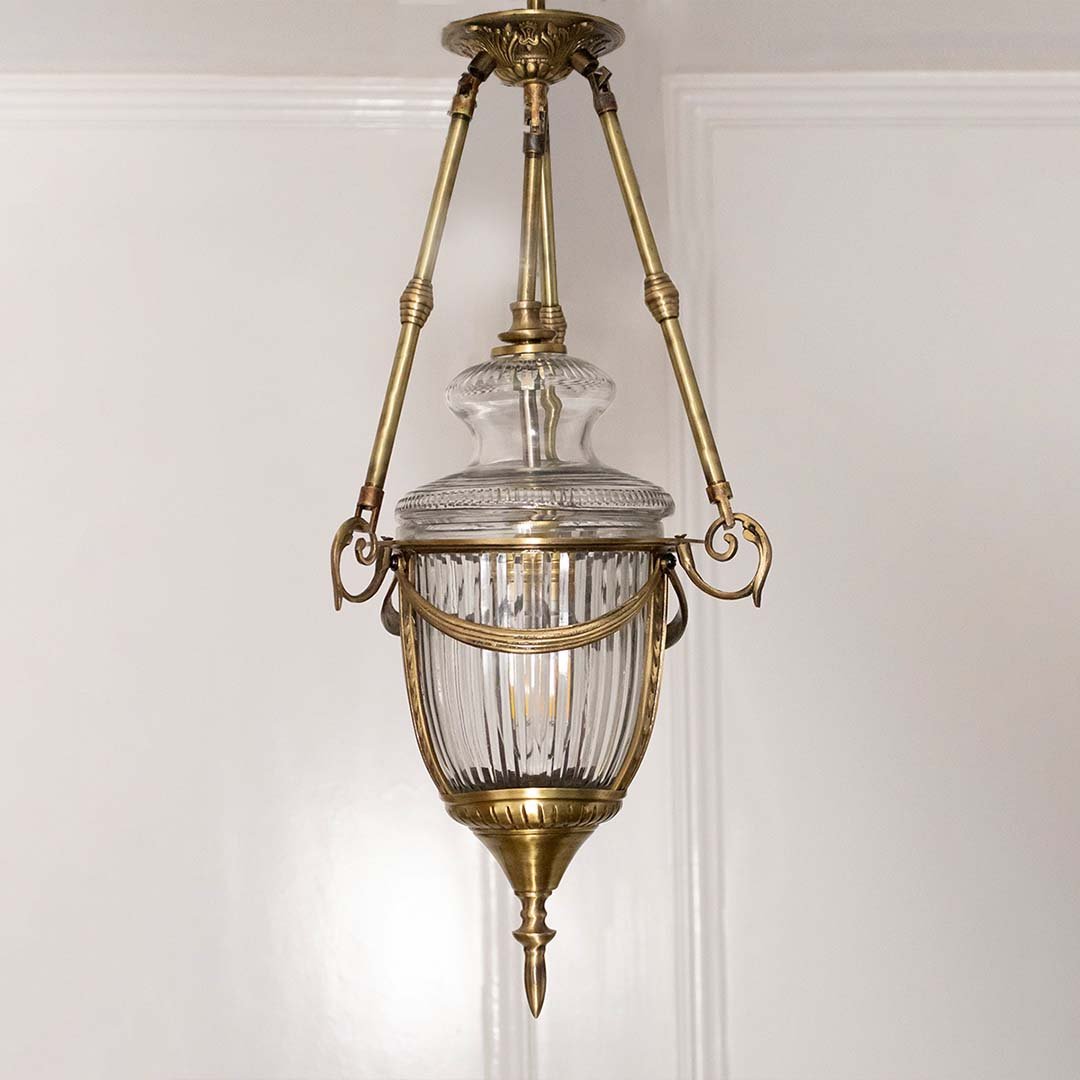 Closeup of antique brass and clear glass lantern pendant light showcasing premium craftsmanship.
