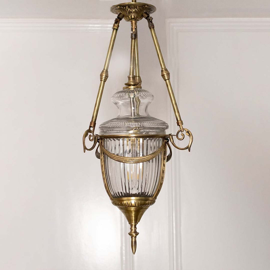 Closeup of antique brass and clear glass lantern pendant light showcasing premium craftsmanship.