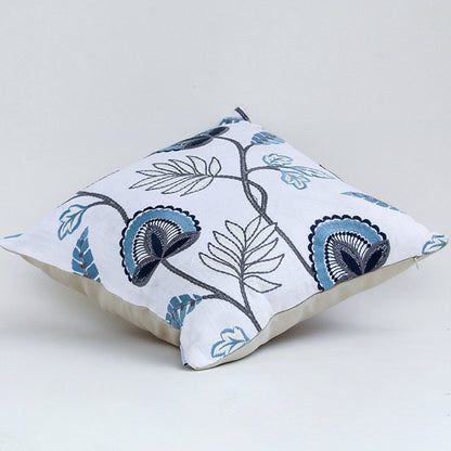 Soft cotton cushion cover with blue floral embroidery shown at an angle creating a cool nature inspired décor accent with a breathable smooth and skin friendly fabric finish for modern styling.