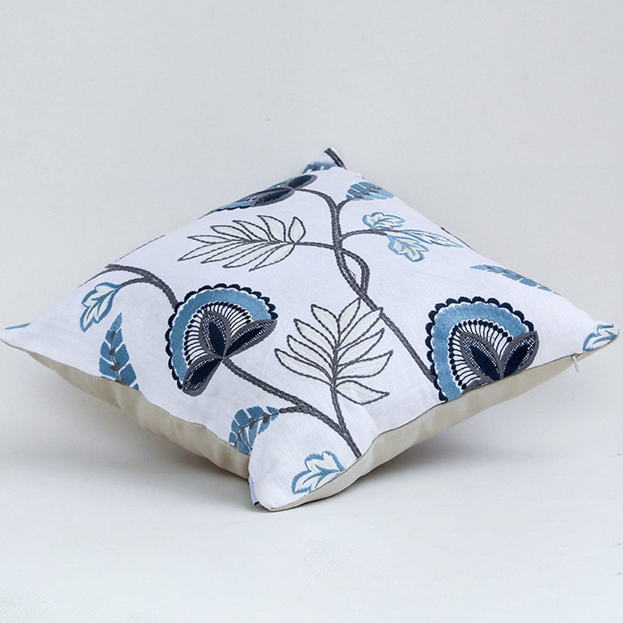 Soft cotton cushion cover with blue floral embroidery shown at an angle creating a cool nature inspired décor accent with a breathable smooth and skin friendly fabric finish for modern styling.