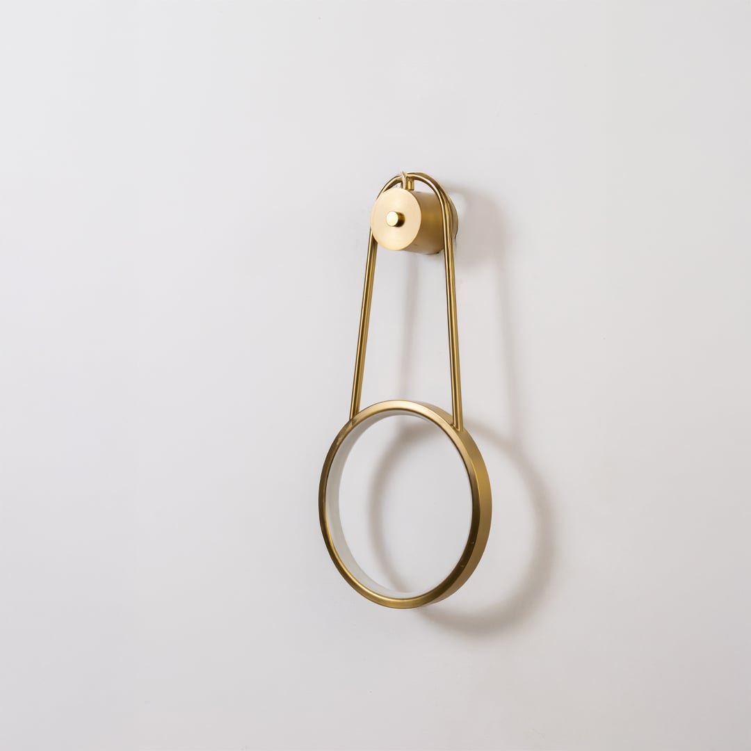 Gold metal ring wall light shown switched off on white background for minimal stylish home decor.