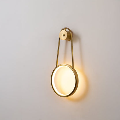 Gold metal ring wall light glowing softly on white background for elegant modern wall decor lighting.