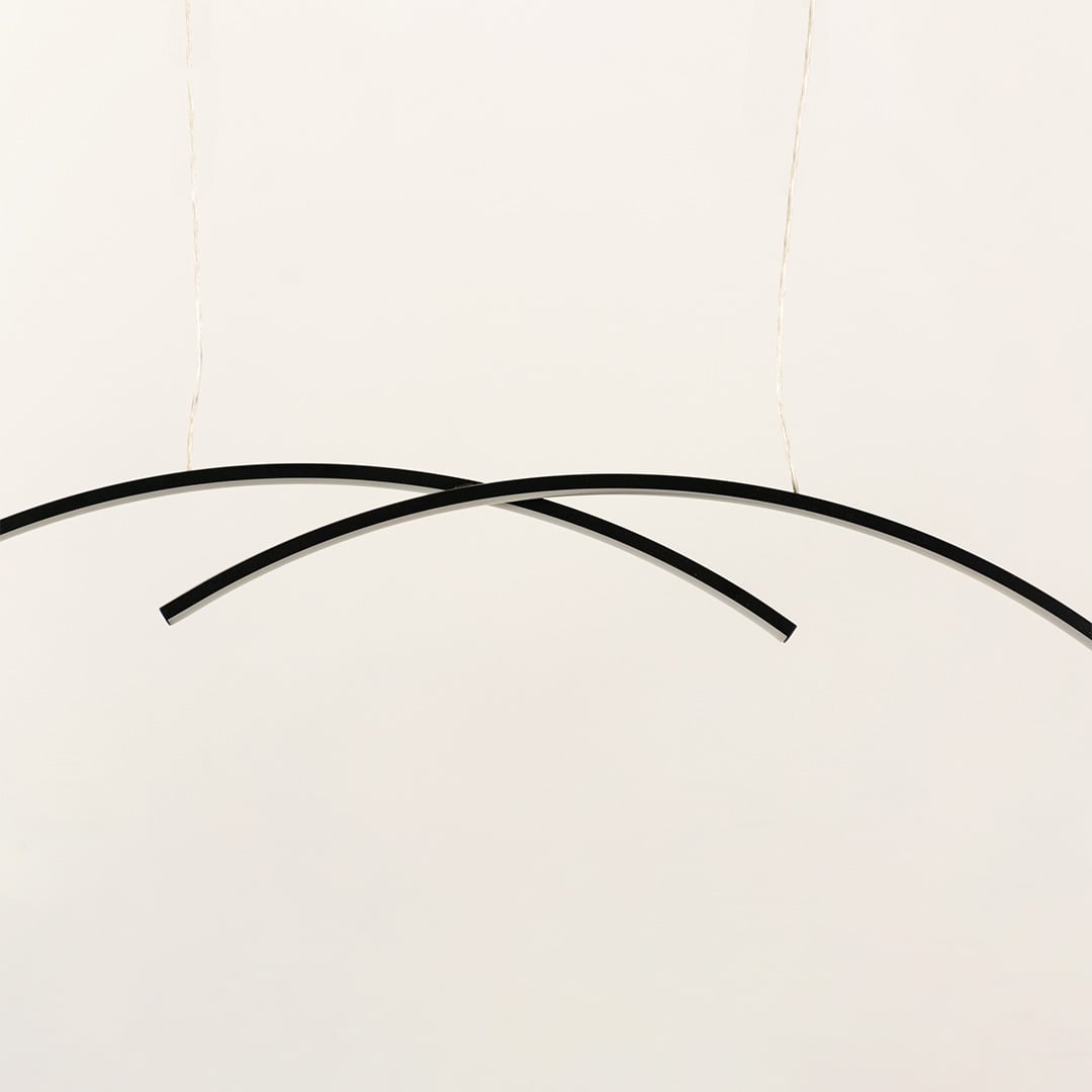 A black curved ceiling light formed by two intersecting arcs ideal for minimal LED lighting and modern designer décor suited for contemporary interiors.