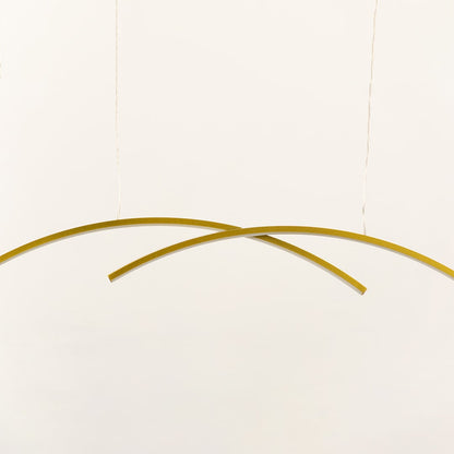 A gold curved ceiling light with intersecting arcs perfect for modern LED lighting and minimal chandelier décor enhancing elegant contemporary home spaces.