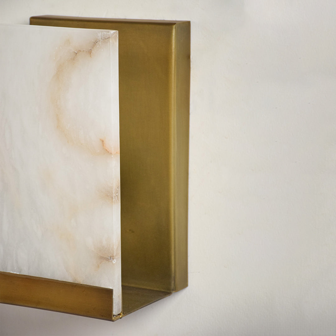 Closeup of marble and gold metal wall light for modern hallway and premium decor styling spaces.
