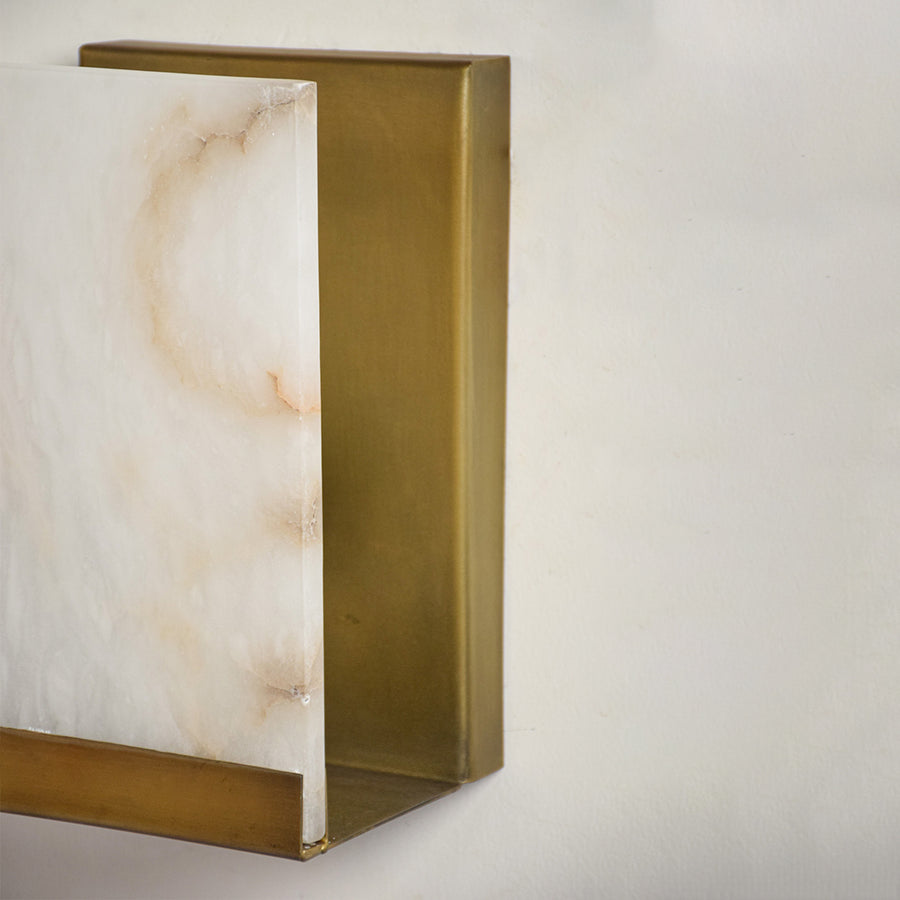 Closeup of marble and gold metal wall light for modern hallway and premium decor styling spaces.