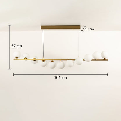 Gold linear ceiling chandelier with globe bulbs measuring 103 cm width and 57 cm height against a white wall background with lights on ideal for modern designer lighting décor.