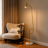 Modern gold arc floor lamp with white marble base beside sofa creating elegant ambient lighting for stylish interiors.