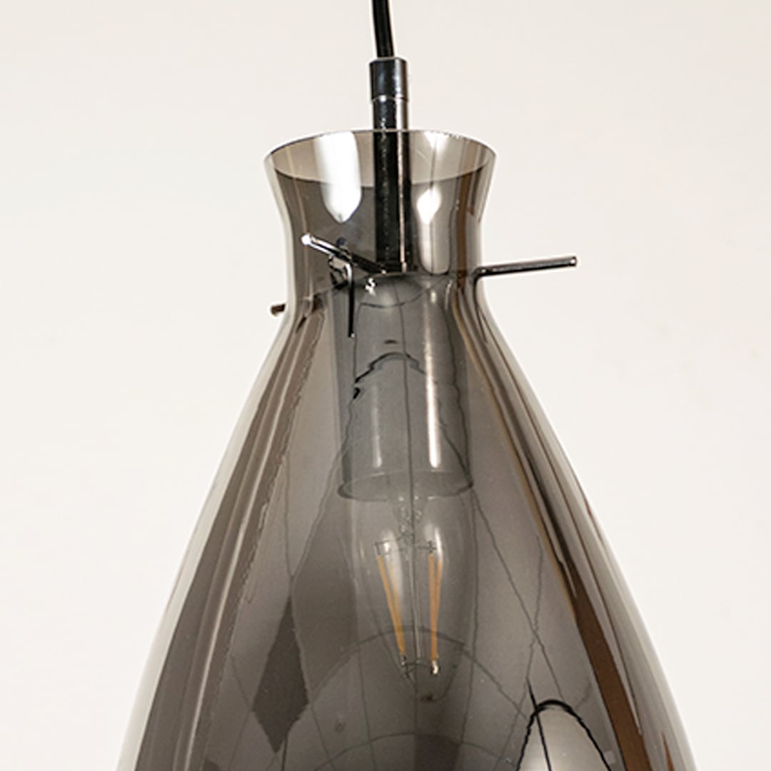 Close view of smoked chrome pendant light showing smooth glass texture elegant curve and polished reflective craftsmanship.