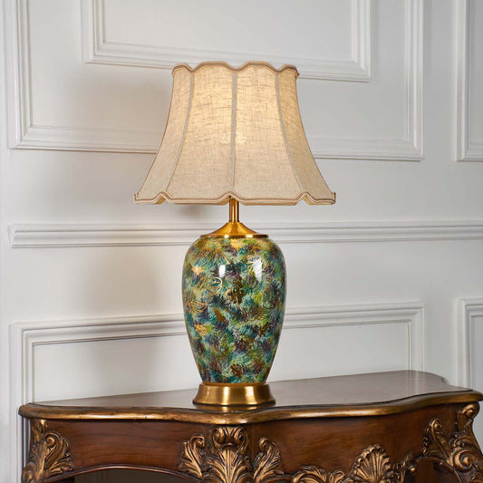 Multicolor floral ceramic table lamp with scalloped fabric shade creating luxurious traditional ambient lighting on a console table.