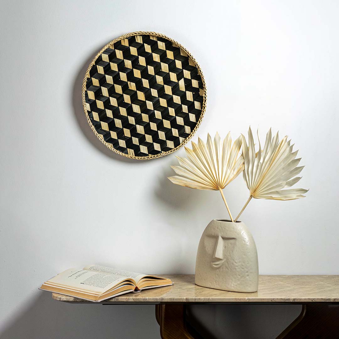 Bamboo woven wall basket with geometric black pattern creating modern boho texture accent in minimalist interior design.