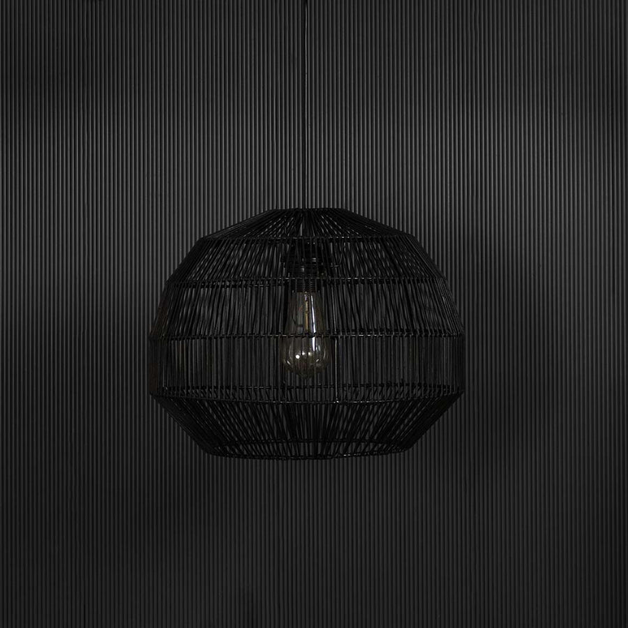 Elegant black rattan pendant light against black background highlighting the woven structure and natural handcrafted finish.