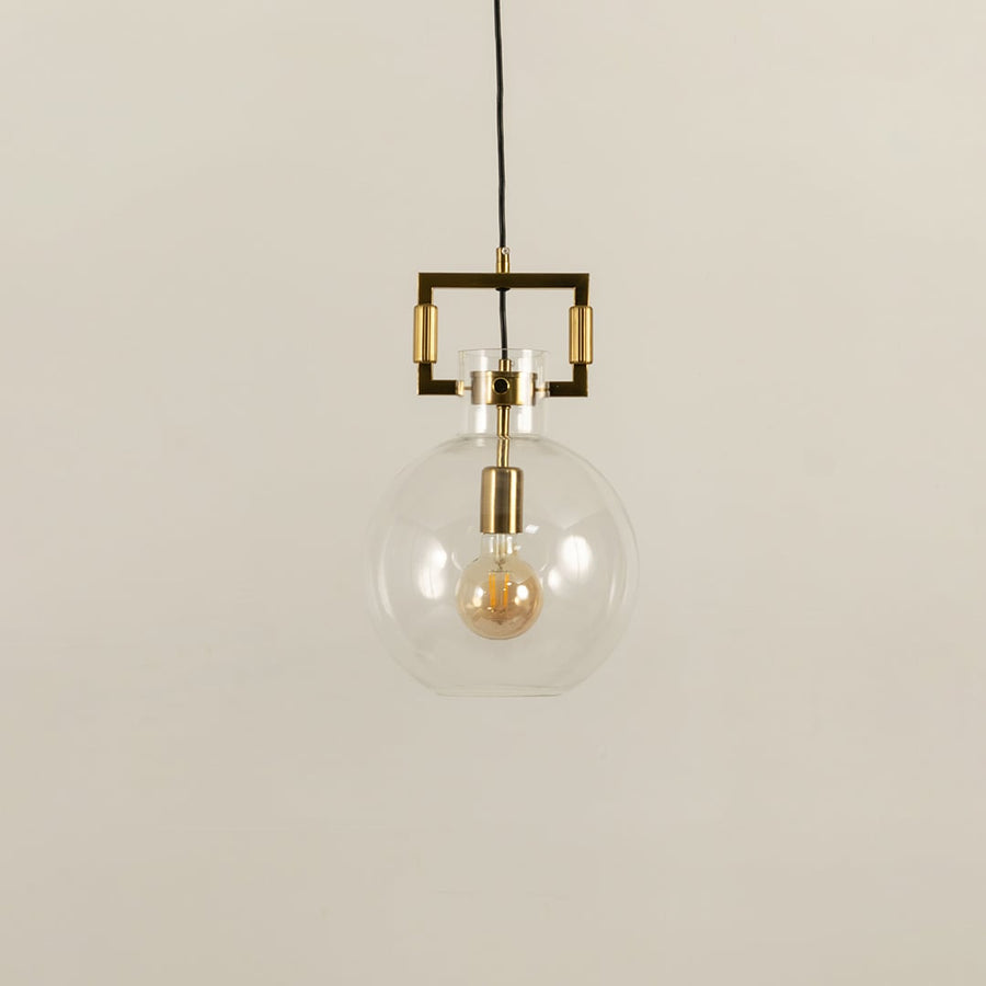 Glass globe pendant light with gold metal detailing shown with light off on a white background emphasizing its sleek minimalist look.
