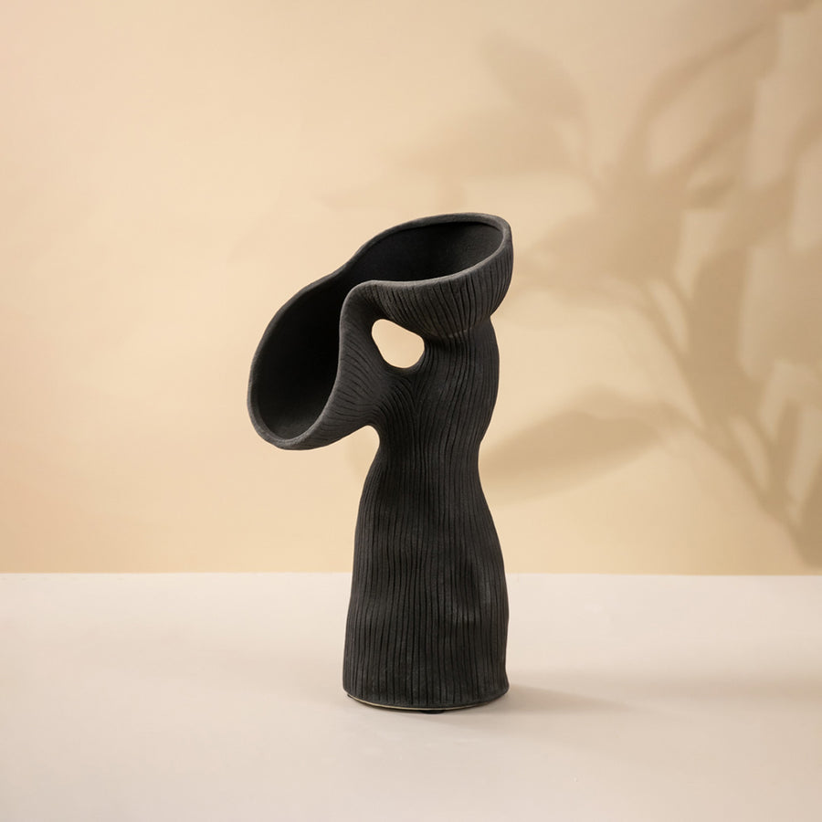 Black ceramic decorative sculpture with abstract curved silhouette for modern tabletop styling and artistic home decor.