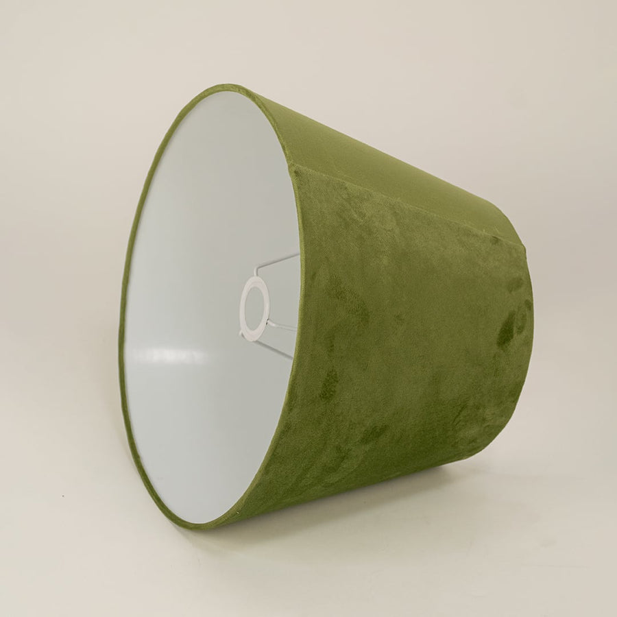 Green velvet lampshade on a white background highlighting its soft fabric finish and modern minimal silhouette.