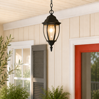 Classic black metal hanging teardrop glass lantern pendant light from porch ceiling next to red entryway door decoration.