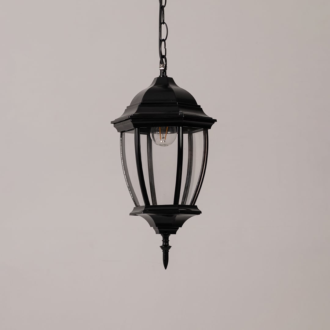 Contemporary black metal hanging lantern light with clear curved glass for stylish outdoor decor.