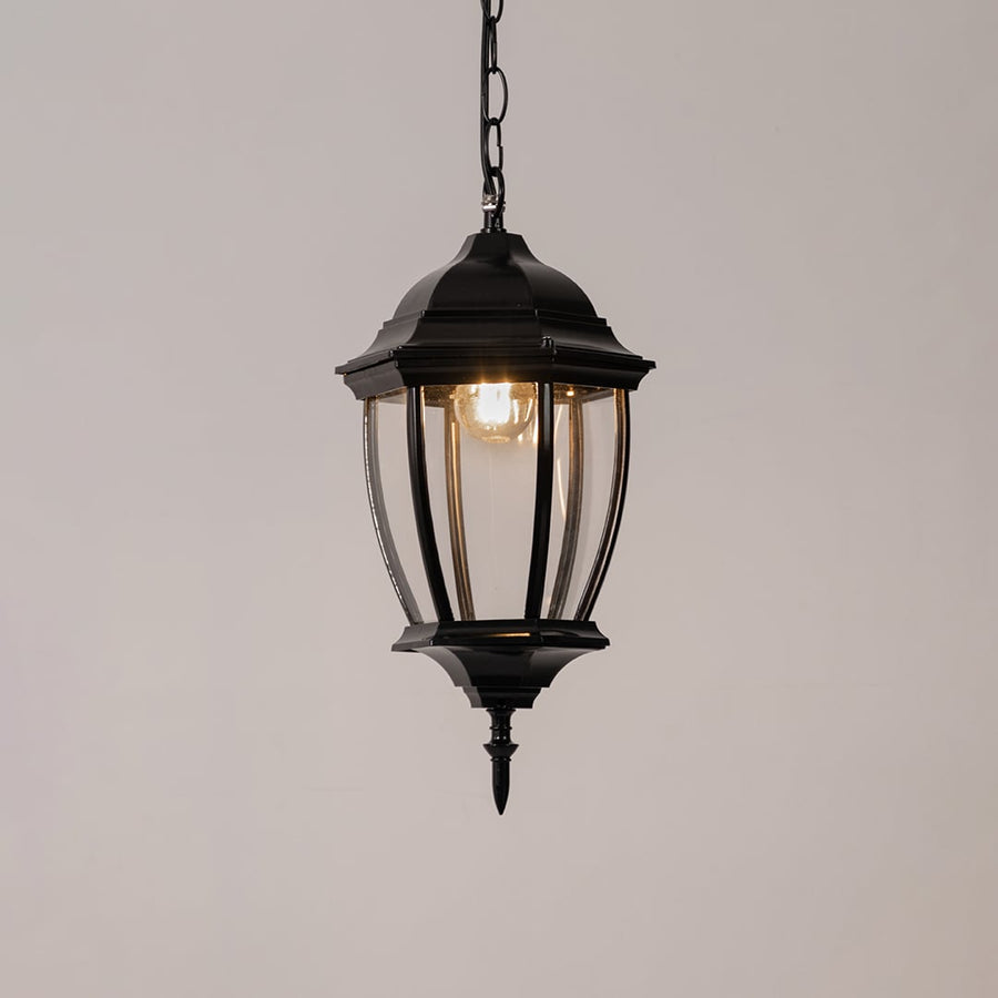 Modern black metal hanging lantern light with warm glow for elegant balcony and patio lighting.