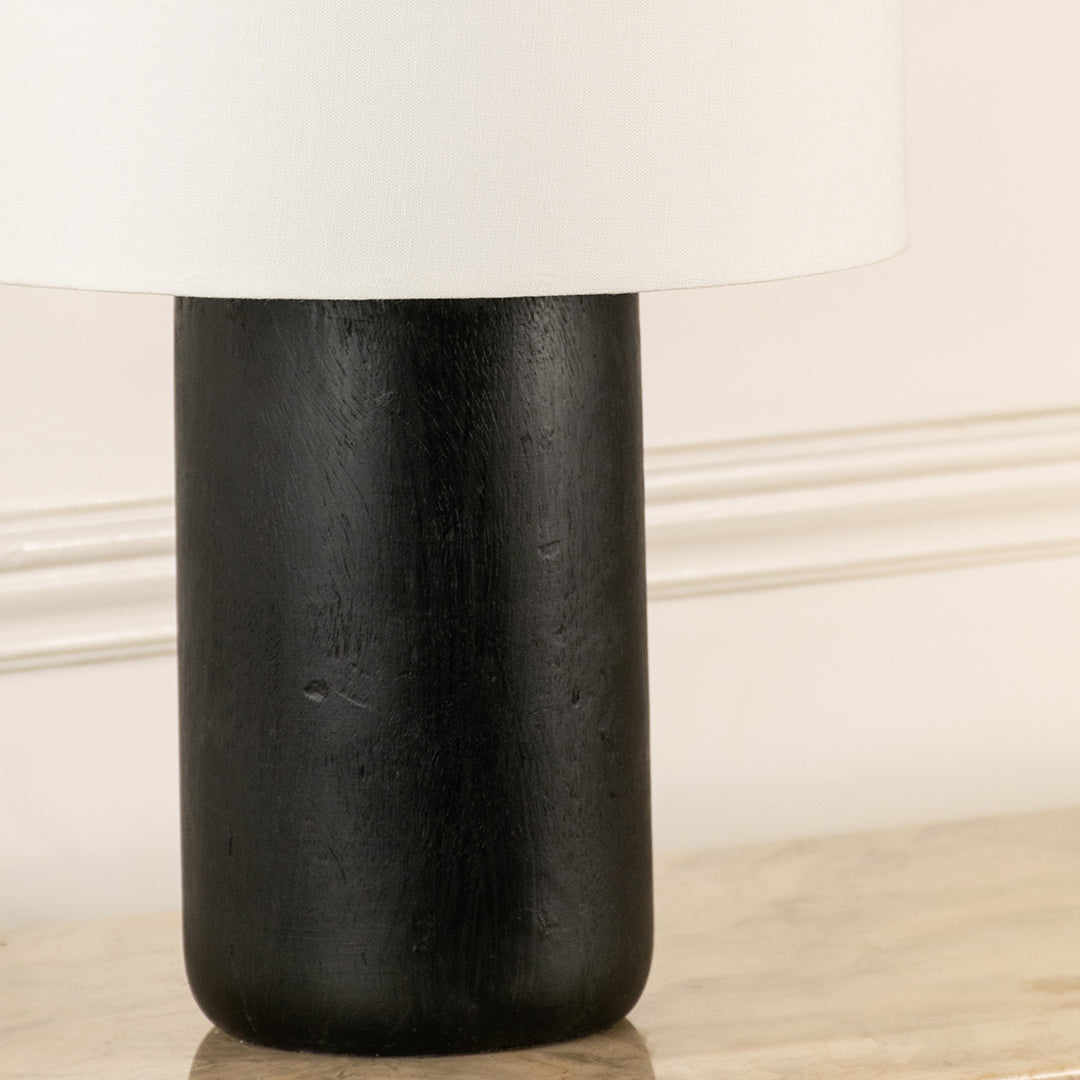 Closeup of black metal table lamp base showing minimal cylindrical design ideal for modern interior decor styling.