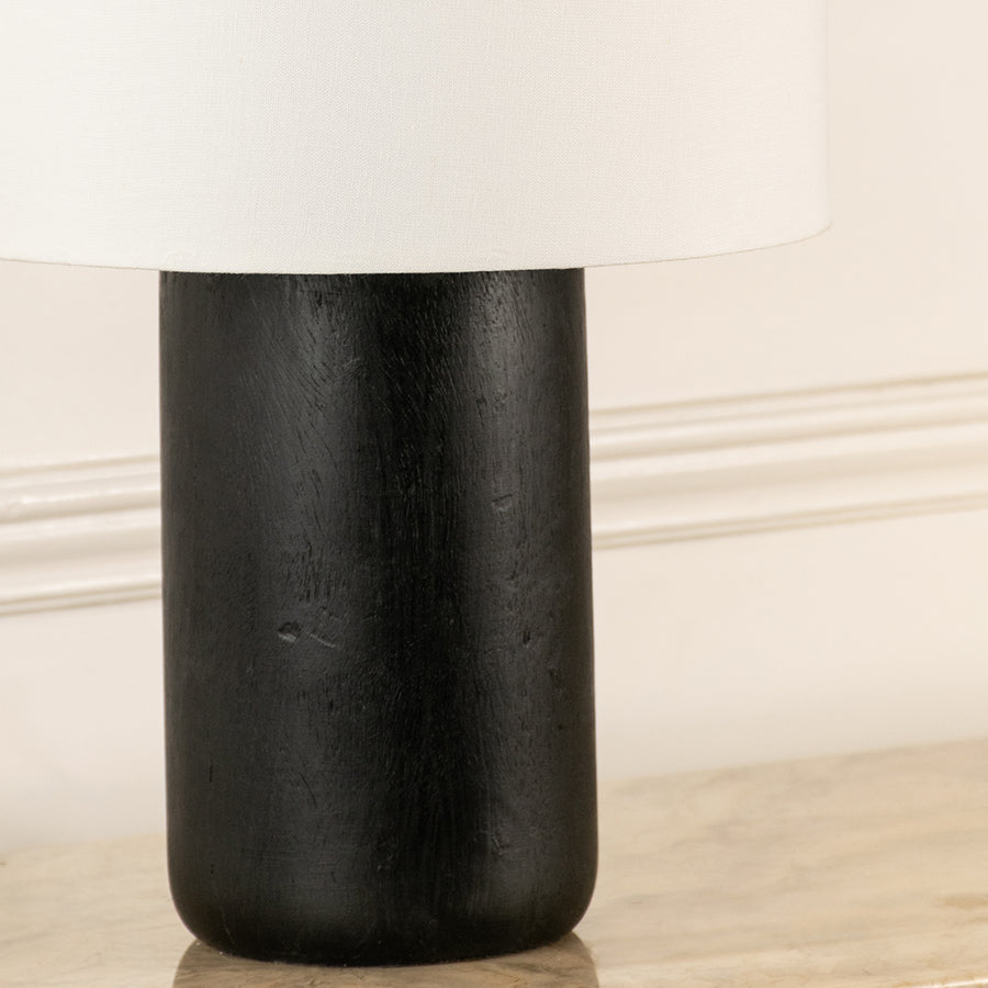 Closeup of black metal table lamp base showing minimal cylindrical design ideal for modern interior decor styling.
