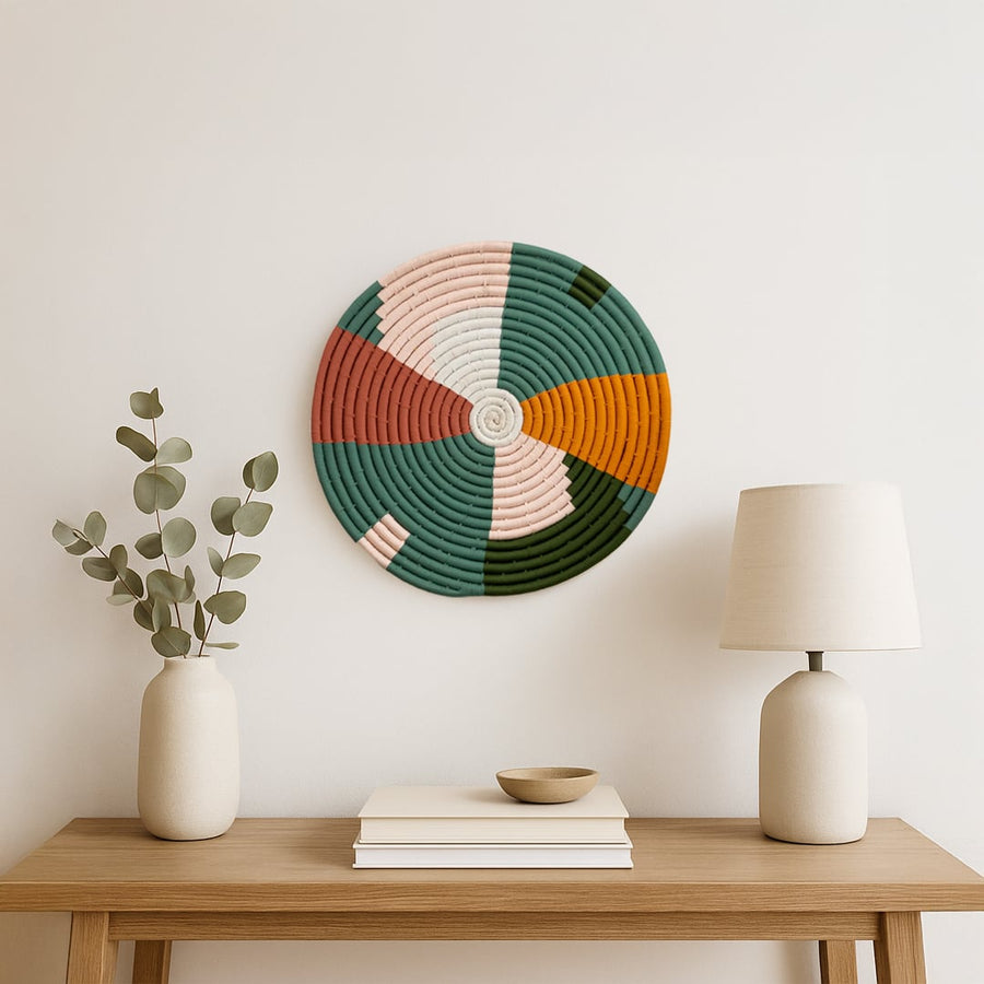 A single multicolor woven wall plate displayed above a wooden console with decor accents adding a soft artistic touch to a calm neutral interior setting.