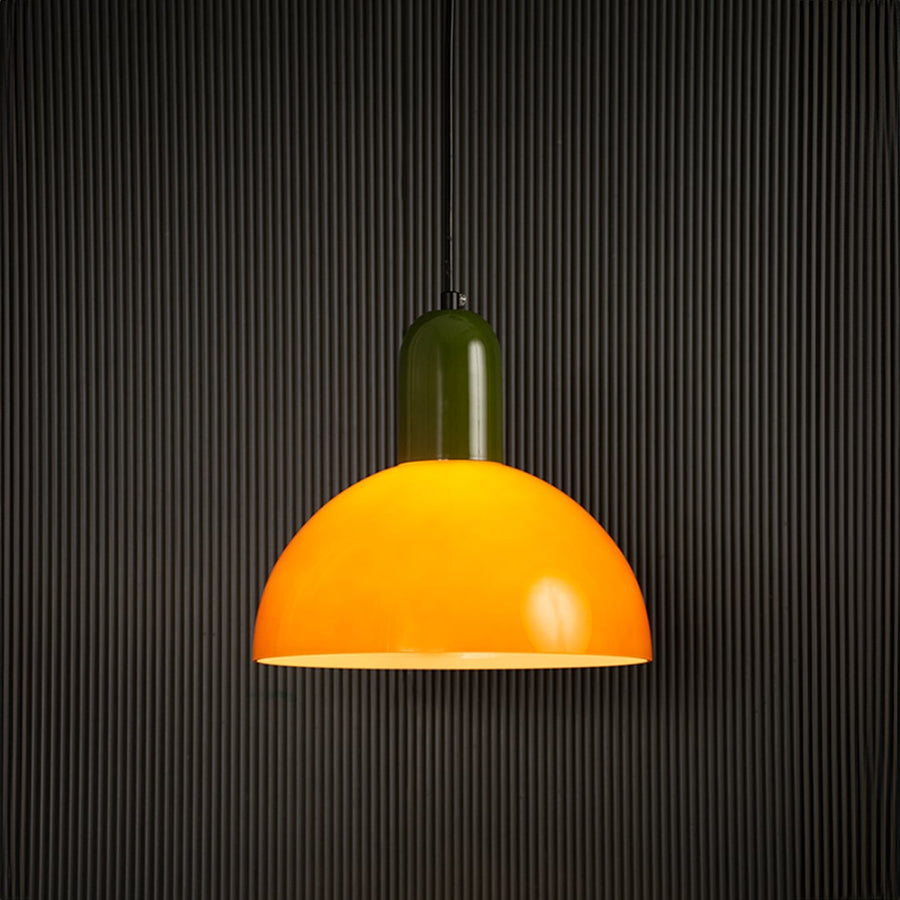 Bold orange and green pendant lamp glowing beautifully on dark background highlighting its smooth finish and lively contemporary design.