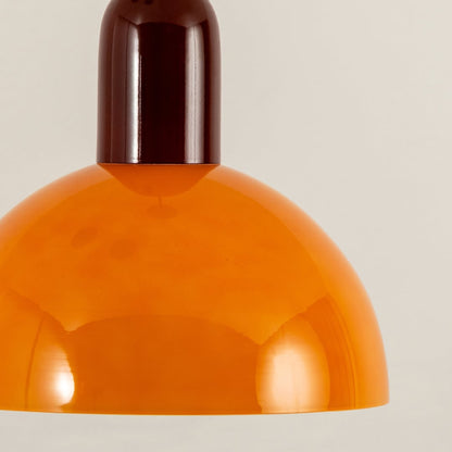 Yellow metal pendant light closeup showcasing smooth curved shade design and luxury decorative lighting appeal.