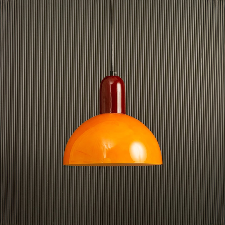 Unlit orange and red hanging pendant lamp on dark background emphasizing its sleek silhouette and playful yet elegant color contrast.