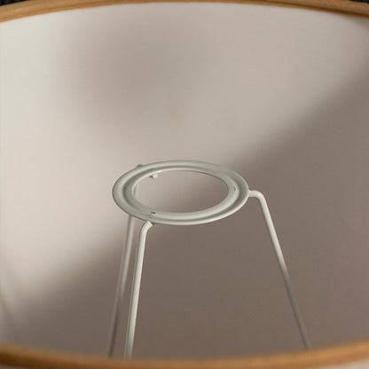 Closeup image of cream pleated fabric lampshade with sturdy metal frame highlighting refined craftsmanship.