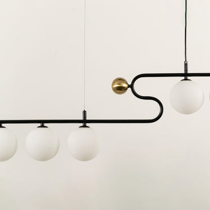 Gold and black metal chandelier with frosted glass globe shades showcasing elegant craftsmanship and modern lighting design.