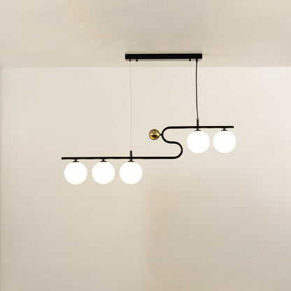 A sculptural black and gold linear chandelier with four glowing white globes hanging against a soft neutral background adding stylish warm lighting and artistic décor.