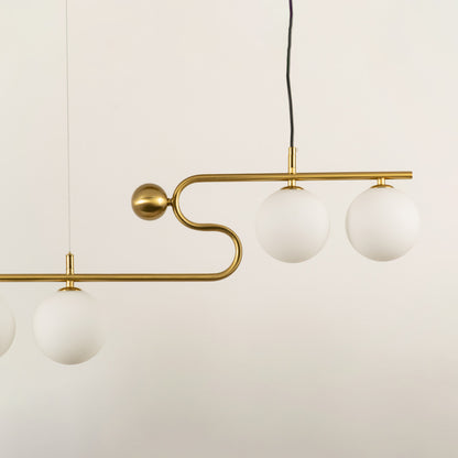 Gold metal chandelier with frosted glass globe shades showcasing elegant curved detailing and modern lighting design.