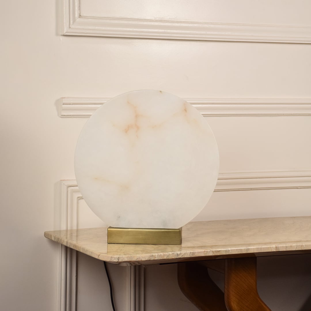 Round marble table lamp unlit on white background with metal base showcasing minimalist design perfect for elegant interior settings.